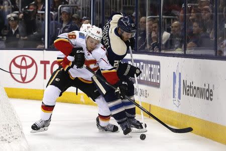 Oct 17, 2014; Columbus, OH, USA; Calgary Flames center Matt Stajan (18) battles for the puck against Columbus Blue Jackets defenseman James Wisniewski (21) during the third period at Nationwide Arena. The Blue Jackets won 3-2. Mandatory Credit: Aaron Doster-USA TODAY Sports