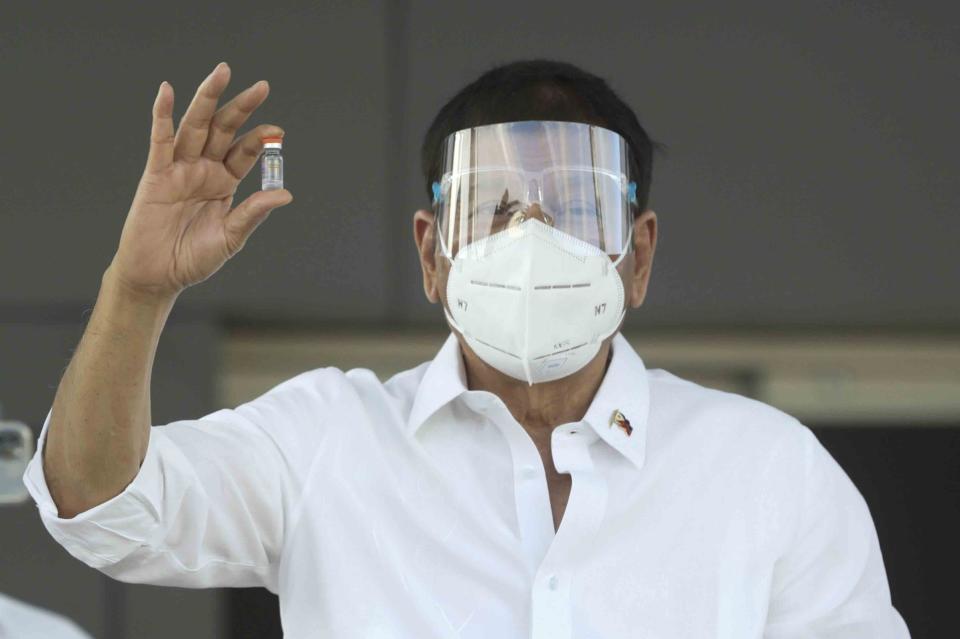 In this photo provided by the Malacanang Presidential Photographers Division, Philippine President Rodrigo Duterte holds a vial containing the Sinovac vaccine from China as it arrives at the Villamor Air Base in Manila, Philippines on Sunday Feb. 28, 2021. The Philippines received its first batch of COVID-19 vaccine Sunday, among the last in Southeast Asia to secure the critical doses despite having the second-highest number of coronavirus infections and deaths in the hard-hit region. (Toto Lozano/ Malacanang Presidential Photographers Division via AP)