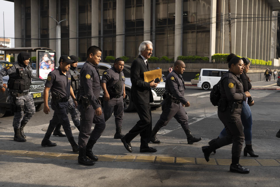 Police escort Guatemalan journalist Jose Ruben Zamora, founder of El Periodico newspaper, to court in handcuffs for a hearing in Guatemala City, Wednesday, May 15, 2024. Zamora has served almost two years of his six-year sentence in a money laundering case that press freedom groups decry as political persecution aimed at silencing a critical voice. Zamora denies the charge and seeks his release. (AP Photo/Moises Castillo)