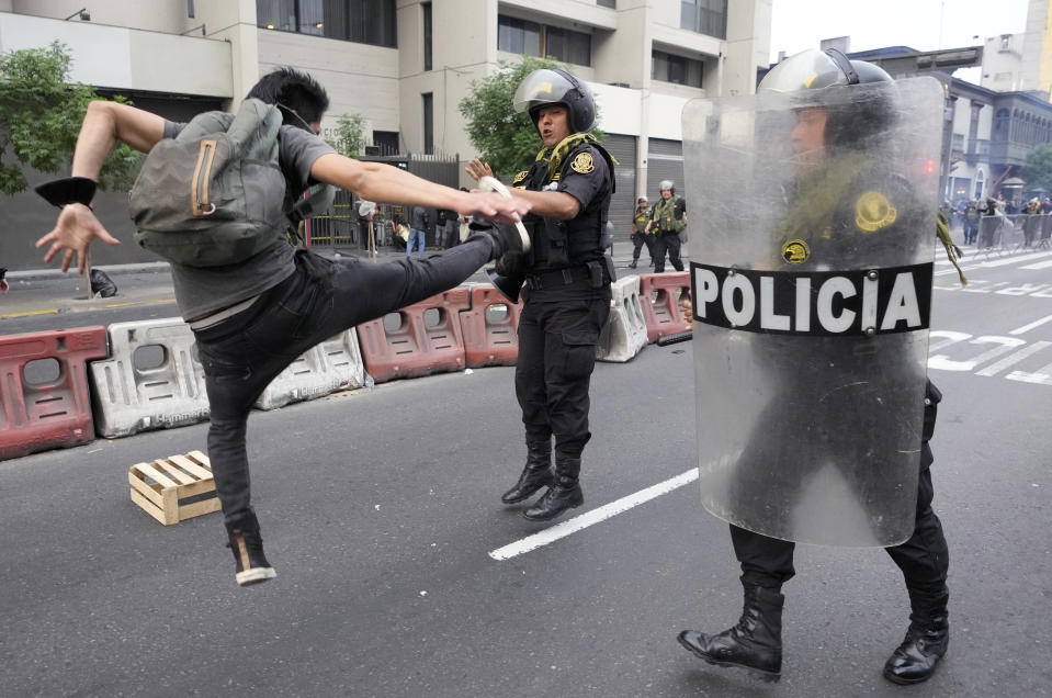 Un seguidor del destituido presidente Pedro Castillo golpea de una patada en el aire a un agente de la policía en una protesta en Lima, Perú, el jueves 8 de diciembre de 2022. El Congreso de Perú votó por la remoción del cargo de Castillo el miércoles y por reemplazarlo con la vicepresidenta, poco después de que Castillo intentase disolver el Legislativo ante la sesión de votación prevista para su destitución. (AP Foto/Fernando Vergara)