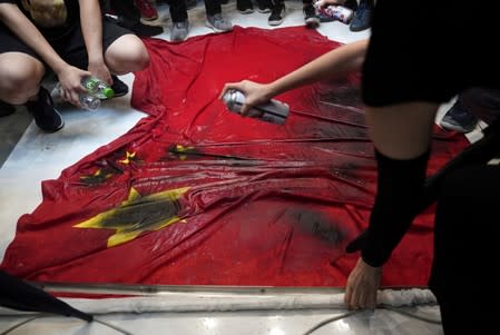 Anti-government protesters destroy a Chinese flag in the New Town Plaza at Sha Tin