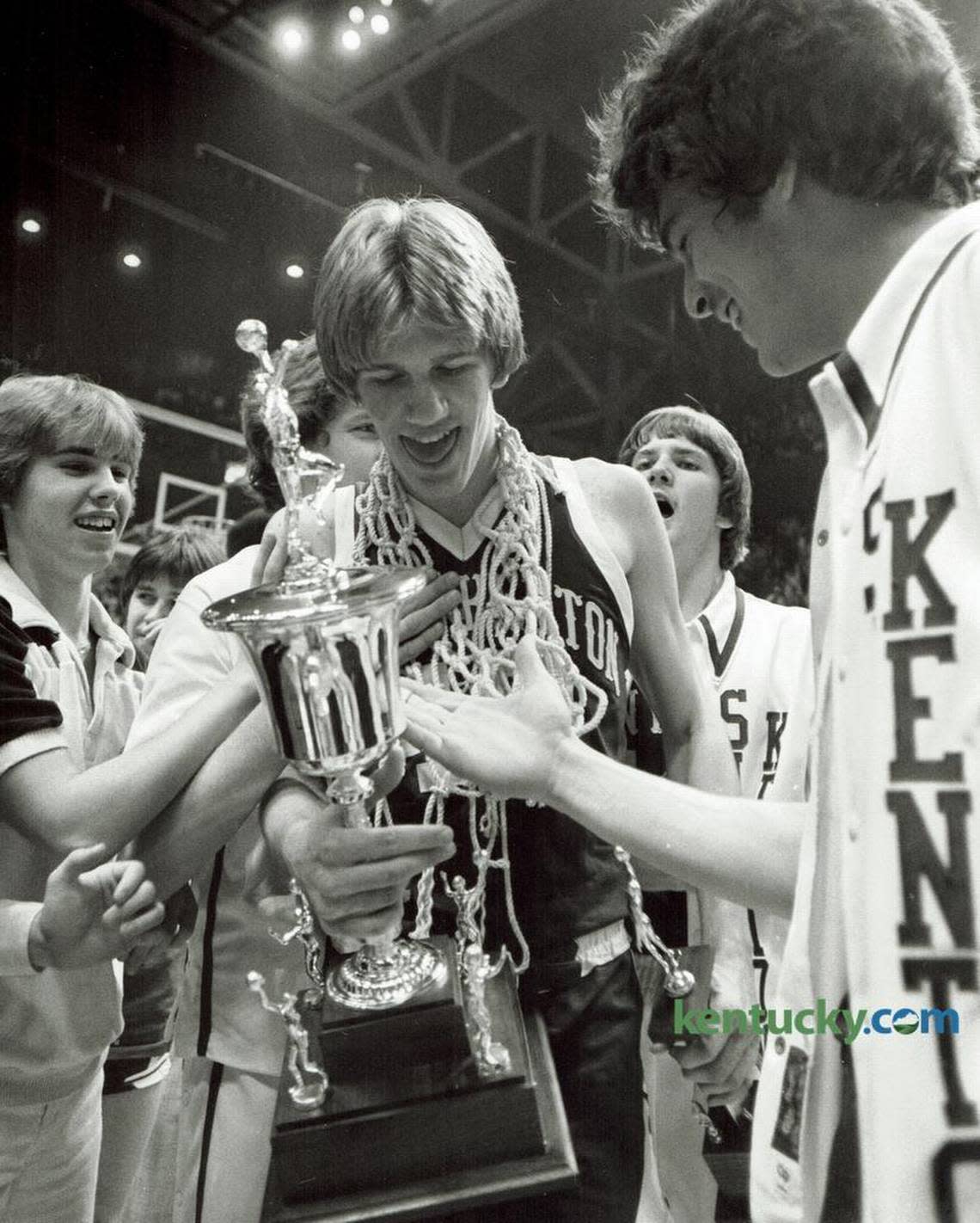 Simon Kenton’s Troy McKinley, center, held the state tournament MVP trophy and celebrated with teammates after beating Mason County 70-63 in the 1981 Sweet 16 championship game at Rupp Arena. The game was played before what was, at that time, a world record crowd for a high school basketball game, 21,287 fans.