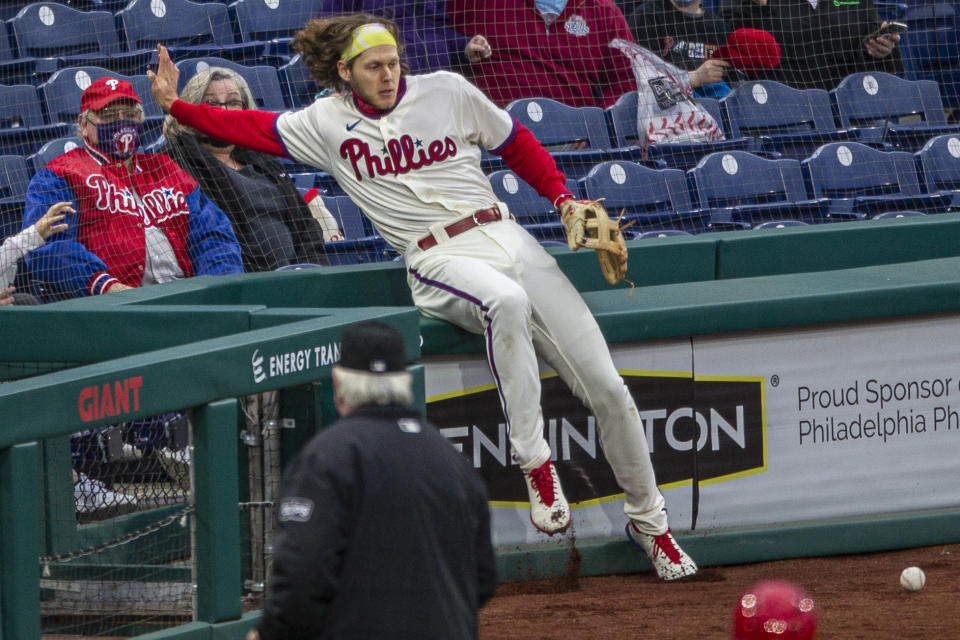 Philadelphia Phillies third baseman Alec Bohm (28) falls into the nets trying to catch a foul ball from St. Louis Cardinals' Dylan Carlson (3) during the sixth inning of a baseball game, Saturday, April 17, 2021, in Philadelphia. (AP Photo/Laurence Kesterson)