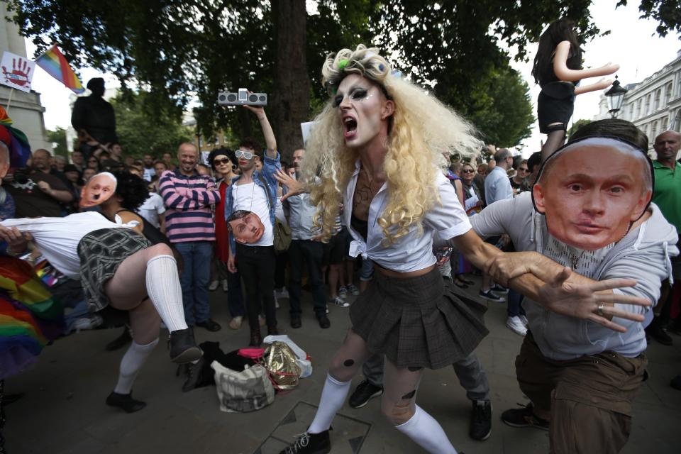 FILE - In this Saturday, Aug. 10, 2013 file photo, demonstrators stage a theatrical play where gays are grabbed by others wearing masks of Russian President Vladimir Putin, during a protest against Russia's new anti-gay law banning "propaganda of nontraditional sexual relations" in central London. Despite seven months of international protests, Russia's law restricting gay-rights activity remains in place leading up to the winter olympic games. Yet the eclectic campaign has heartened activists in Russia and, without question, caught the attention of its targets - including organizers and sponsors of the Sochi Olympics that open on Feb. 7. (AP Photo/Lefteris Pitarakis)