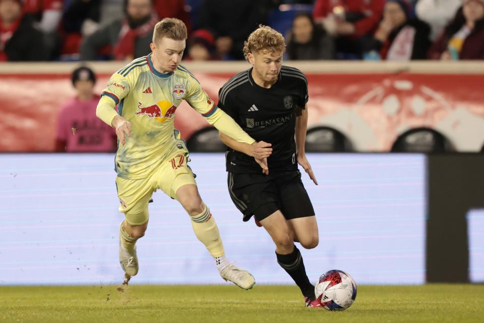 Mar 4, 2023; Harrison, New Jersey, USA; New York Red Bulls forward Cameron Harper (17) dribbles against Nashville SC forward Jacob Shaffelburg (14) during the first half at Red Bull Arena.