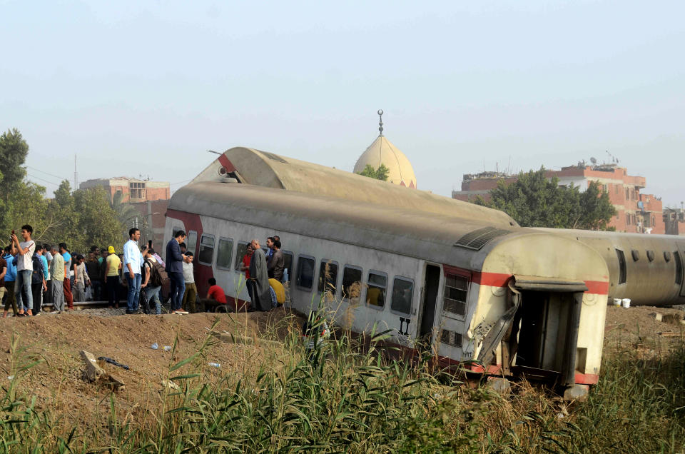 FILE - In this Sunday, April 18, 2021 file photo, people gather at the site where a passenger train derailed killing at least 11 people and injuring at least 98 others, near Banha, Qalyubia province, Egypt. Egypt’s transportation minister on Tuesday said he sacked the country’s top railway official, following three train accidents in less than a month that left at least 29 people dead and over 300 injured. (AP Photo/Tarek Wagih, File)