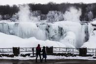 A couple looks out over the partially frozen American side of the Niagara Falls during sub-freezing temperatures in Niagara Falls, Ontario March 3, 2014. REUTERS/Mark Blinch