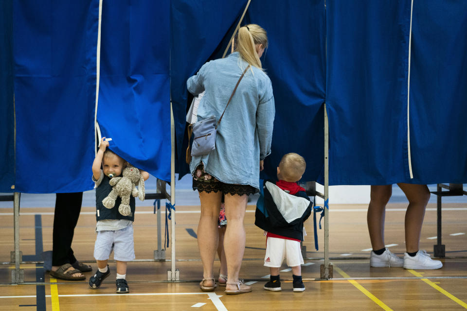 Children accompany their parents in the voting booth during voting at Sundby Idraetspark polling station in Copenhagen, Denmark, during the general elections on Wednesday June 5, 2019. (Martin Sylvest/Ritzau Scanpix via AP)