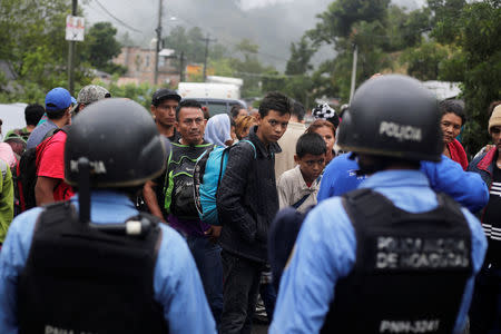 Honduran migrants stand at a police checkpoint near the Agua Caliente border while waiting to cross into Guatemala and join a caravan trying to reach the U.S., in the municipality of Ocotepeque, Honduras, October 17, 2018. REUTERS/Jorge Cabrera