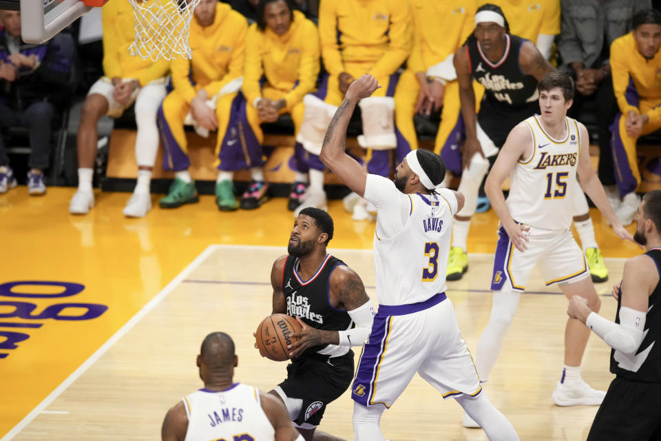 Los Angeles Clippers forward Paul George, second from front left, drives against Los Angeles Lakers forward Anthony Davis (3) during the first half of an NBA basketball game in Los Angeles, Sunday, Jan. 7, 2024. (AP Photo/Eric Thayer)