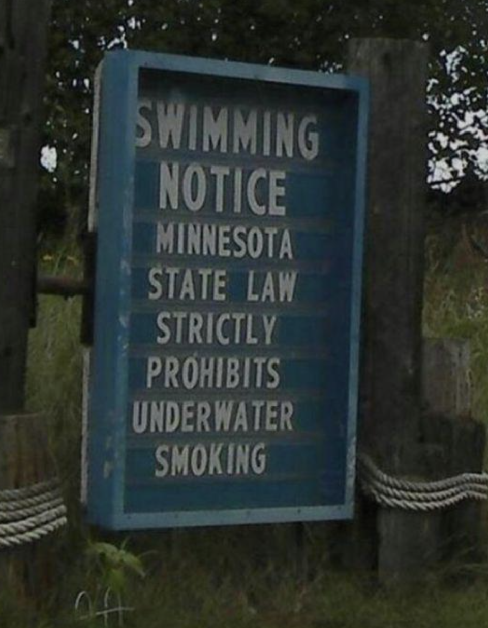 Sign reads "Swimming Notice: Minnesota State Law strictly prohibits underwater smoking."