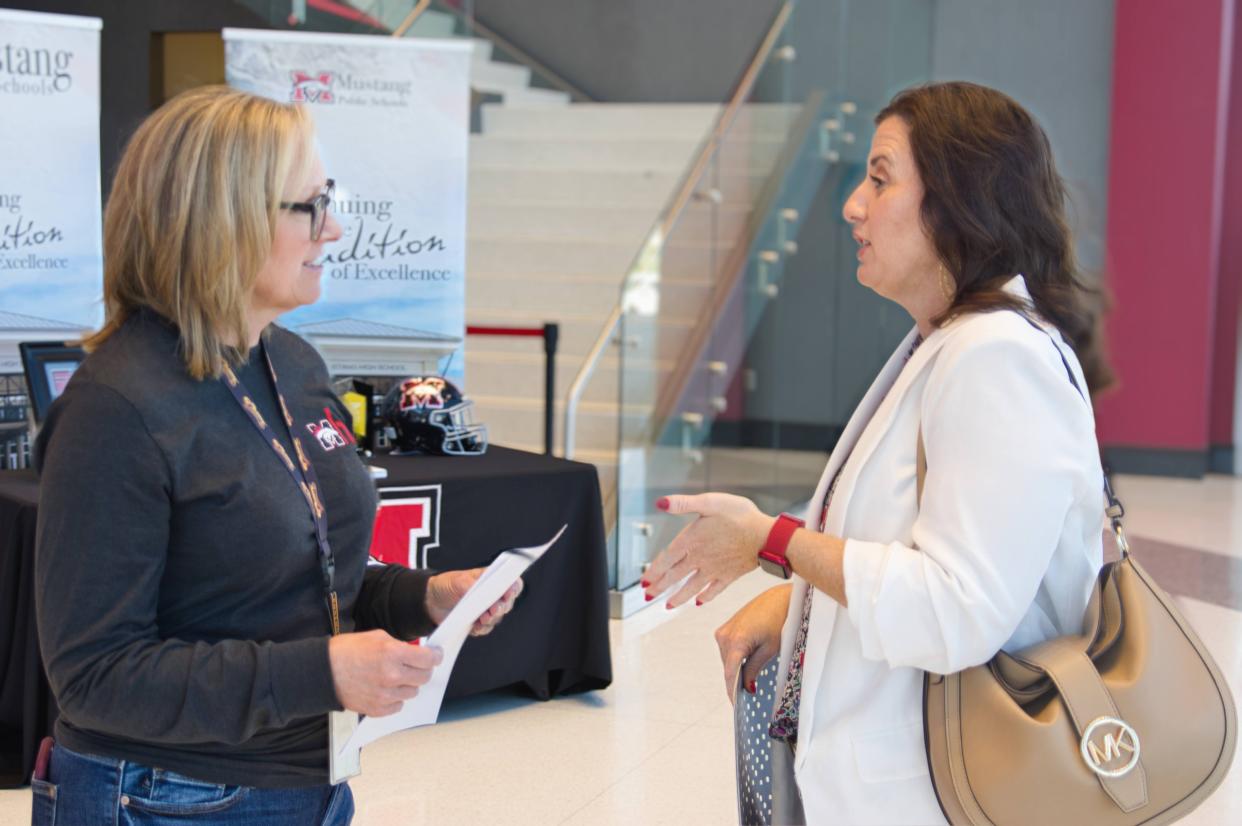 Meagan Cole (right) gives her resume to Human Resources Specialist Cheryl Rodgers at the Mustang Public Schools job fair April 11, 2024.