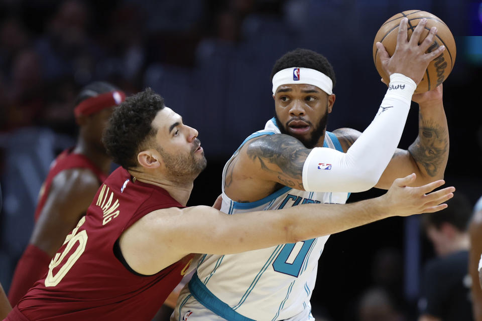 Charlotte Hornets forward Miles Bridges plays against Cleveland Cavaliers forward Georges Niang during the first half of an NBA basketball game, Monday, March 25, 2024, in Cleveland. (AP Photo/Ron Schwane)