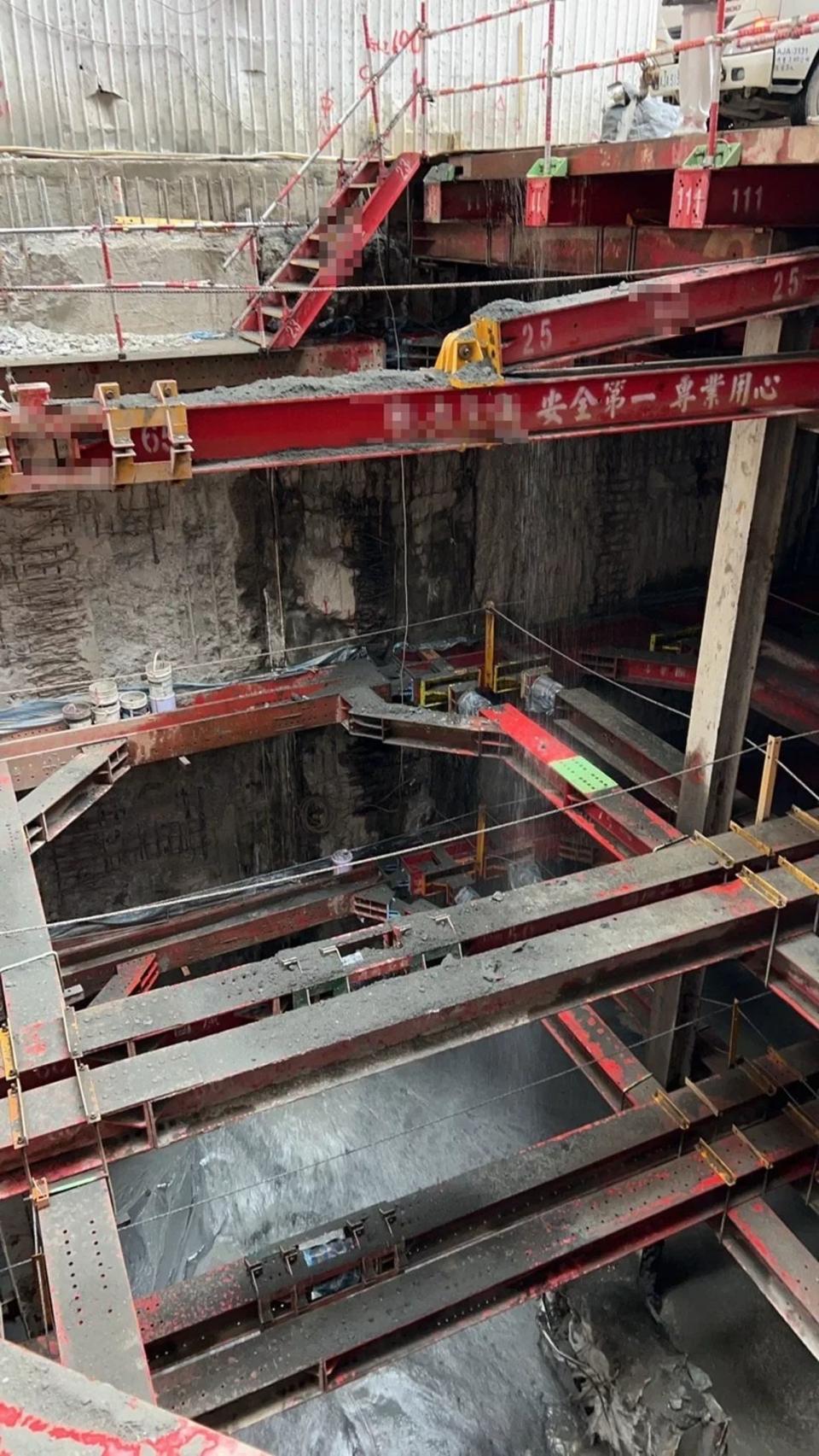 新北市三重區福隆路一處新建大樓工地，下午因地下室連續壁破洞，導致地下水往工地流，造成一旁大樓傾斜。（翻攝畫面）