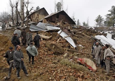 Police stand amidst the rubble after a hillside collapsed onto a house at Laden village, west of Srinagar, March 30, 2015. REUTERS/Danish Ismail