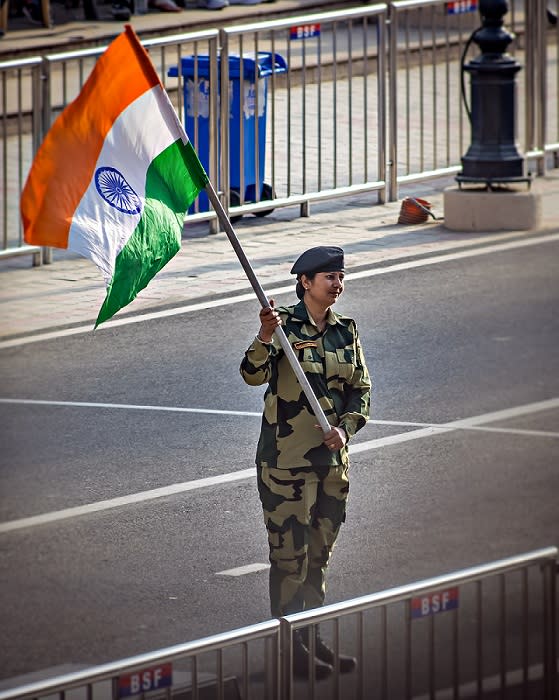 Wagah border, Punjab, India - April 14th, 2019 : A lady officer of Indian Border Security Force, waving Indian National Flag during evening military drill jointly done by Indian & Pakistani forces