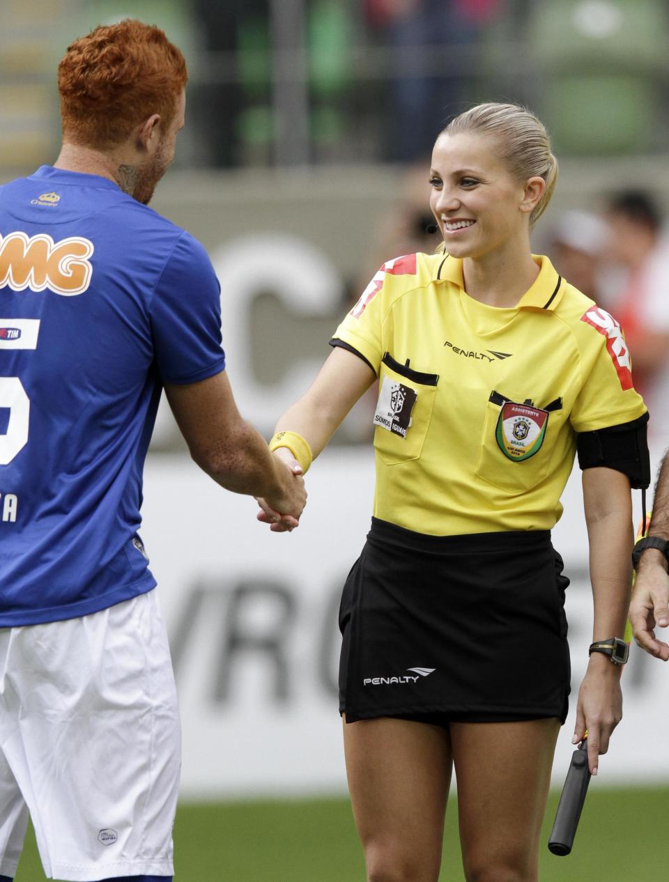 Brazil's referee assistant Fernanda Colombo Uliana is greeted by Cruzeiro's Souza before the Brazilian championship soccer match between Atletico Mineiro and Cruzeiro in Belo Horizonte