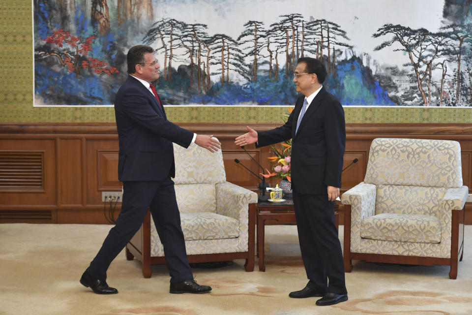 European Commission Vice President Maros Sefcovic, left, approaches to shake hands with Chinese Premier Li Keqiang before their meeting at the Diaoyutai State Guesthouse in Beijing Thursday, April 25, 2019. (Parker Song/Pool Photo via AP)