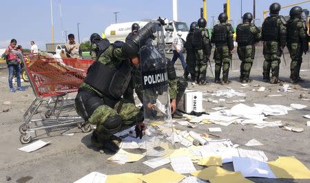 Military policemen recover electoral materials outside a polling station vandalised by members of the teacher's union CNTE in Juchitan, state of Oaxaca June 7, 2015. REUTERS/Stringer