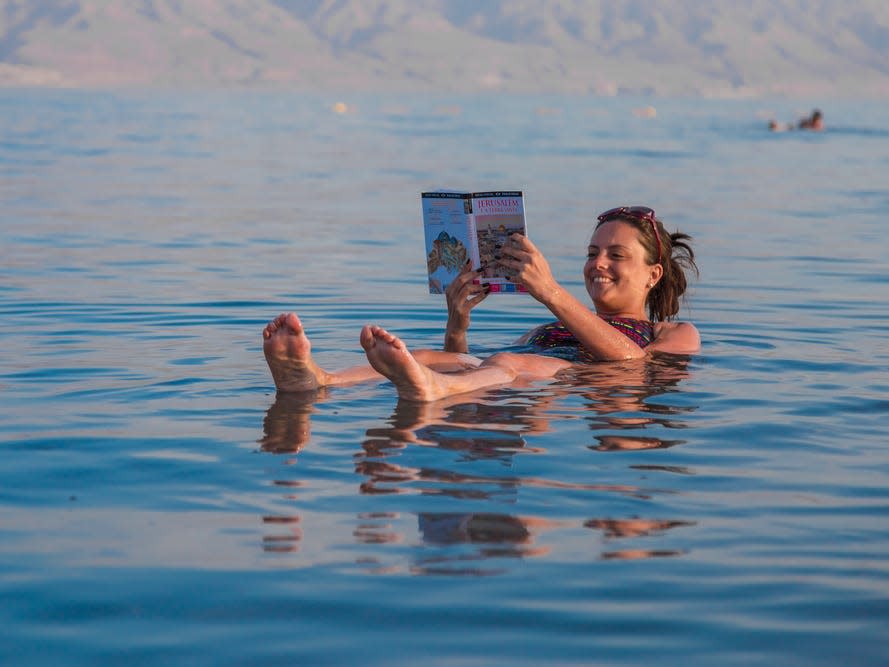 woman reading water beach