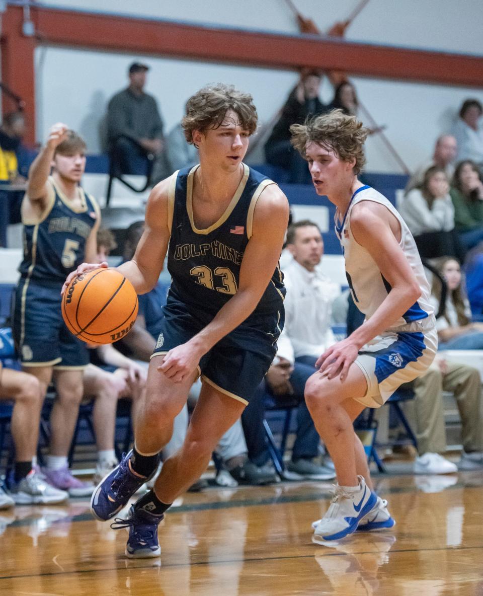 Reece Bloomberg (33) drives past Ethan McDonald (4) during the Gulf Breeze vs Jay boys basketball game at Jay High School on Tuesday, Jan. 18, 2022.