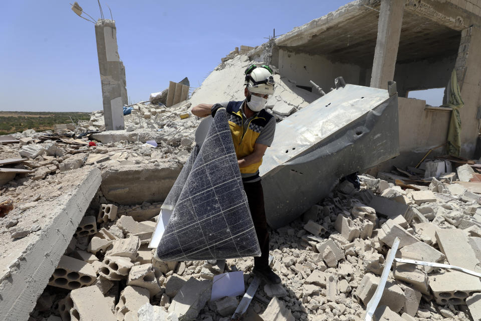 A civil defense worker inspects a damage house after shelling hit the town of Ibleen, a village in southern Idlib province, Syria, Saturday, July 3, 2021. Artillery fire from government-controlled territory Saturday killed at least eight civilians in Syria's last rebel enclave, most of them children, rescue workers and a war monitor said. (AP Photo/Ghaith Alsayed)