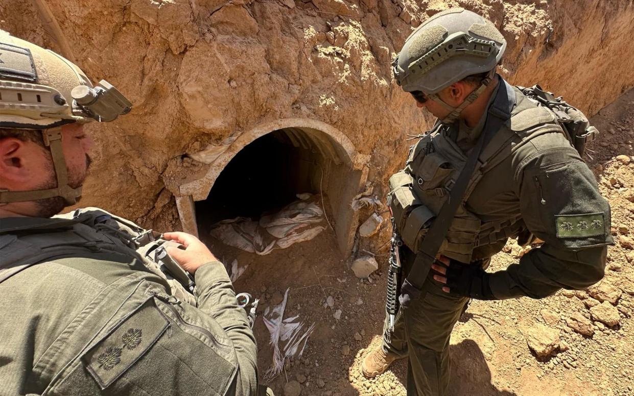 Israeli soldiers check the entrance of a tunnel during operations to investigate and destroy it in central Gaza