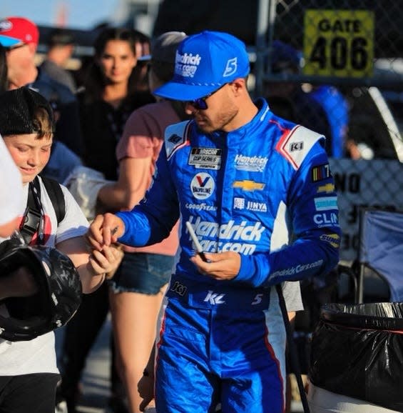 Kyle Larson signs autographs before walking out to the starting grid prior to Saturday's Coke Zero Sugar 400.