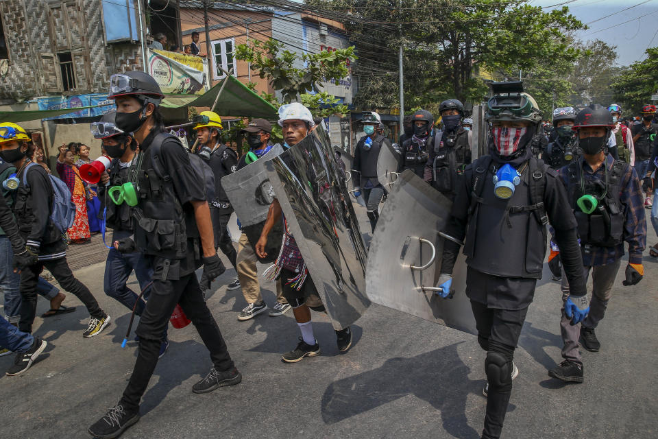 Anti-coup protesters with makeshift shields walk to take positions in Mandalay, Myanmar, Tuesday, March 9, 2021. Demonstrators in Myanmar's biggest city came out Monday night for their first mass protests in defiance of an 8 p.m. curfew, seeking to show support for an estimated 200 students trapped by security forces in a small area of one neighborhood. (AP Photo)