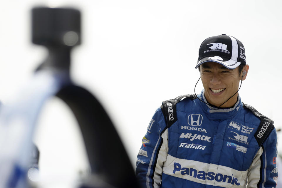 Takuma Sato smiles as he waits for the start of a practice session for Sunday's IndyCar series auto race, Saturday, Aug. 18, 2018, in Long Pond, Pa. (AP Photo/Matt Slocum)