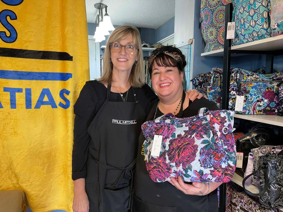 Owner Christina Matias-Arroyo and stylist Rhonda Crowe show off the Vera Bradley purse being given away as a door prize during the 15th anniversary of the salon Nov. 27.