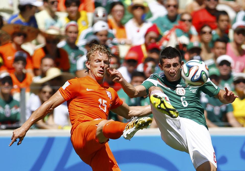 Kuyt of the Netherlands and Mexico's Herrera fight for the ball during their 2014 World Cup round of 16 game at the Castelao arena in Fortaleza