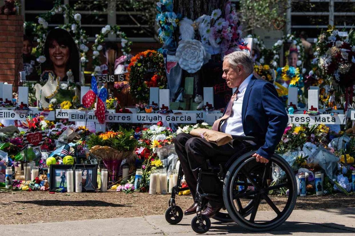 Texas Governor Greg Abbott arrives while US President Joe Biden and First Lady Jill Biden pay their respects at a makeshift memorial outside of Robb Elementary School in Uvalde, Texas