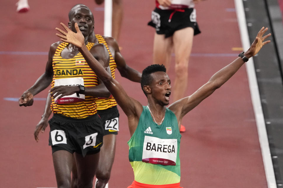 Selemon Barega, of Ethiopia, celebrates after winning the men's 10,000-meter run at the 2020 Summer Olympics, Friday, July 30, 2021, in Tokyo. (AP Photo/Charlie Riedel)