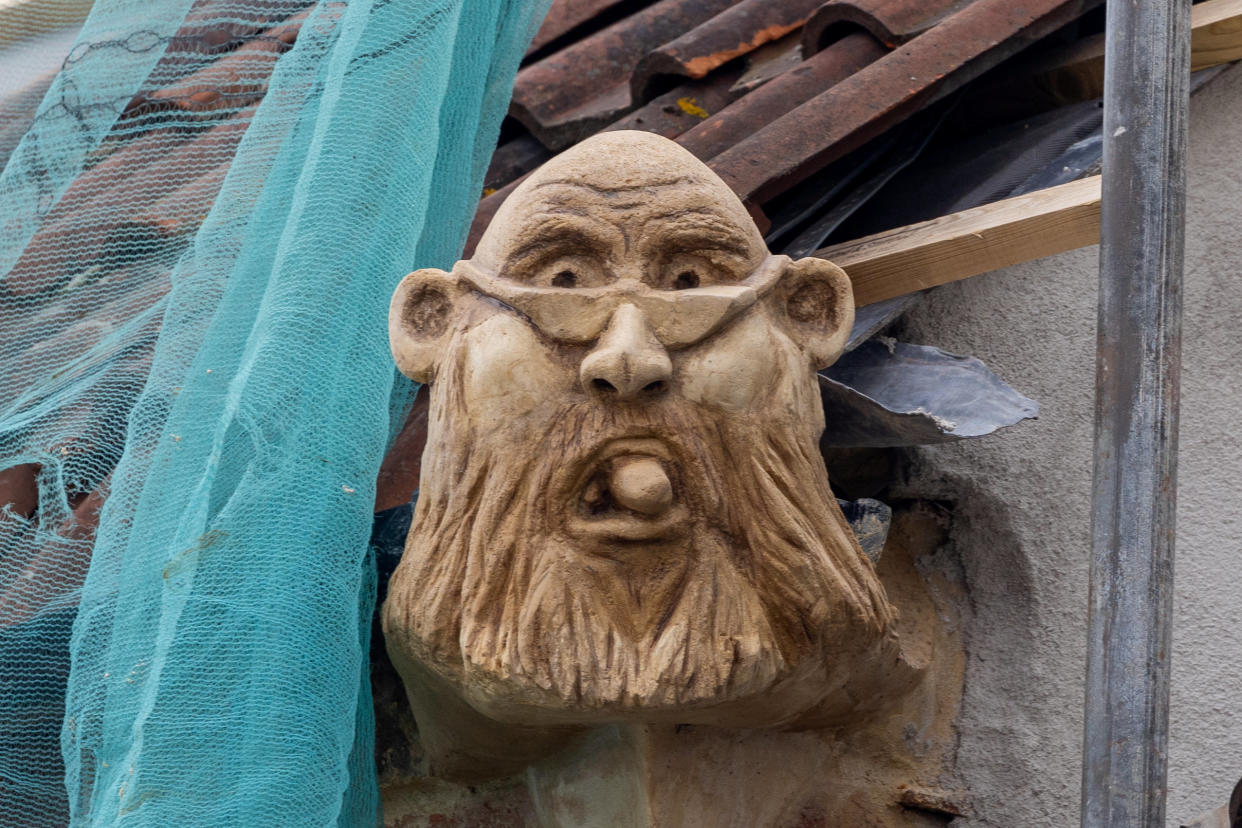 Michael Thomas has installed a stone gargoyle at one end of of his building project to ridicule a local councillor who he believes holds a grudge against him. (SWNS)