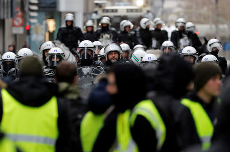 Demonstrators face riot police during the "yellow vests" protest against higher fuel prices, in Brussels, Belgium, December 8, 2018. REUTERS/Yves Herman