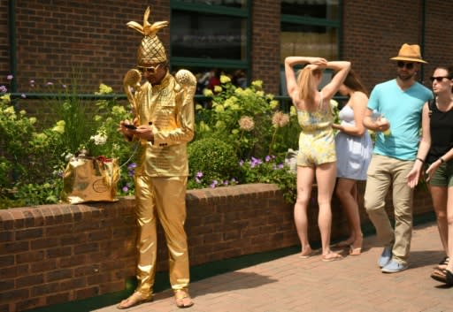 A man dresses as the men's Wimbledon tennis trophy