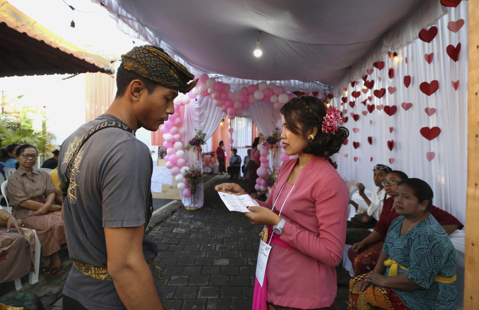 A man waits for his turn to vote at a Valentine's Day themed polling station during the presidential and legislative election in Denpasar, Bali, Indonesia, Wednesday, Feb. 14, 2024. (AP Photo/Firdia Lisnawati)