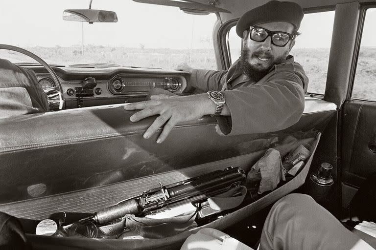 Fidel Castro es entrevistado por un reportero en 1964. Se observa un rifle de asalto en el bolsillo del asiento del auto