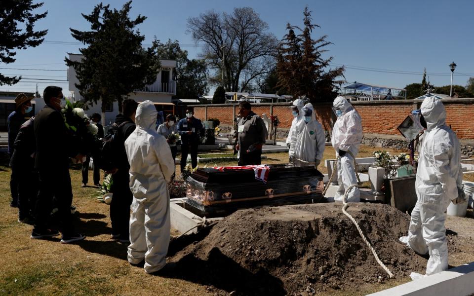 Family members say their last goodbyes to a relative who died from the coronavirus at a local cemetery on the outskirts of Mexico City - Reuters