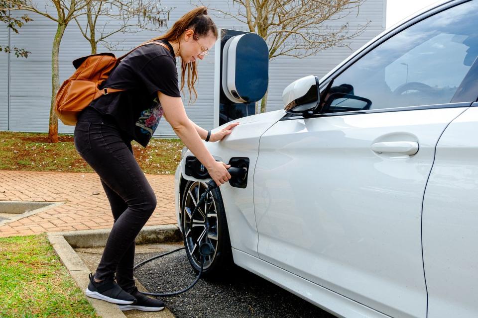 woman near the electric refueling station carrying her car