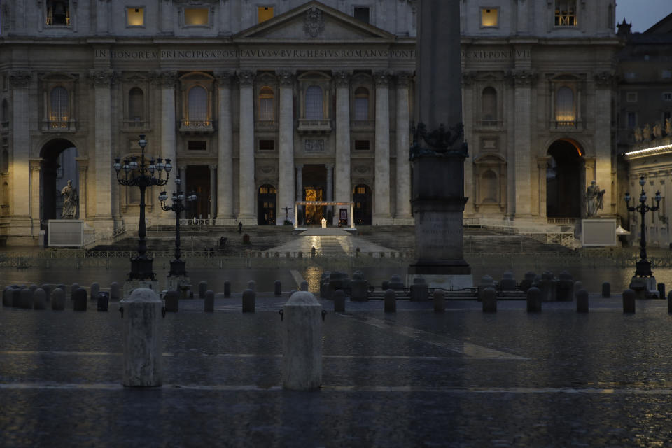 Pope Francis, small white figure at center, delivers the Urbi and Orbi prayer (Latin for To the City and To the World) in an empty St. Peter's Square, at the Vatican, Friday, March 27, 2020. Praying in a desolately empty St. Peter's Square, Pope Francis on Friday likened the coronavirus pandemic to a storm laying bare illusions that people can be self-sufficient and instead finds "all of us fragile and disoriented" and needing each other's help and comfort. The new coronavirus causes mild or moderate symptoms for most people, but for some, especially older adults and people with existing health problems, it can cause more severe illness or death. (AP Photo/Alessandra Tarantino)