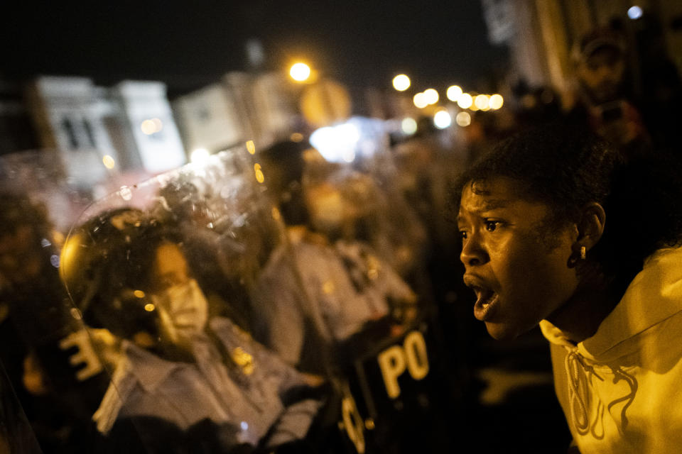A black woman pictured screaming at a police line.