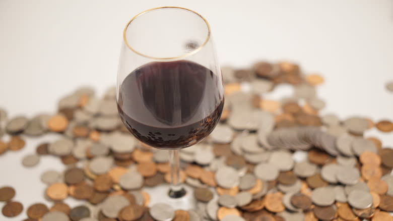 Glass of wine surrounded by coins