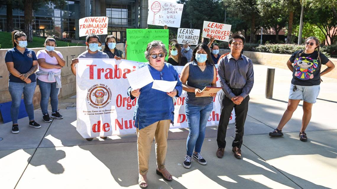 Myrna Martinez Nateras, center, program director for American Friends Service Committee, leads a group opposing the federal Farm Workforce Modernization Act outside the Federal Building in downtown Fresno on Monday, Aug. 29, 2022.