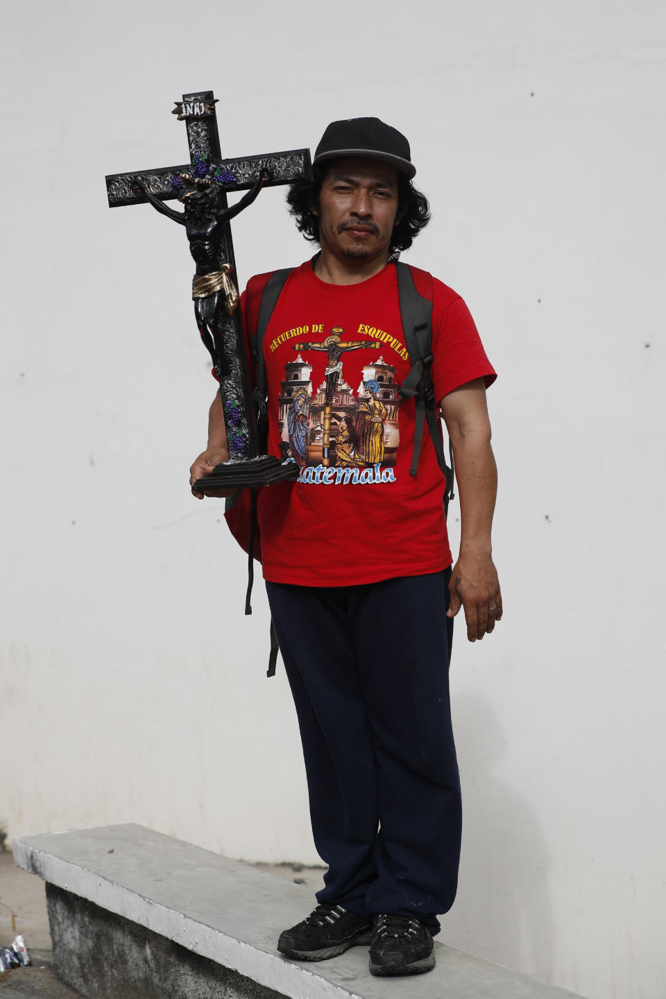 Yarlin Lorenzo Munguia, a 30-year-old from Cortez, Honduras, holds a replica of the Black Christ of Esquipulas as he poses for a portrait while traveling with a caravan of migrants that stopped briefly to rest in Quezaltepeque, Guatemala, Friday, Jan. 17, 2020. Lorenzo said he bought the religious icon when his group passed through the Guatemalan town of Esquipulas, for whom the Christ in named for, as a way to ask for protection for the group as they walk north in hopes of reaching the distant United States. (AP Photo/Moises Castillo)