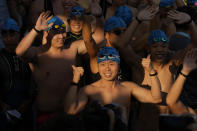 Competitors line up for a harbor race at the Victoria Harbor in Hong Kong, Sunday, Dec. 12, 2021. Hundreds of people took part in traditional swim across iconic Victoria Harbor after two years of suspension. (AP Photo/Kin Cheung)