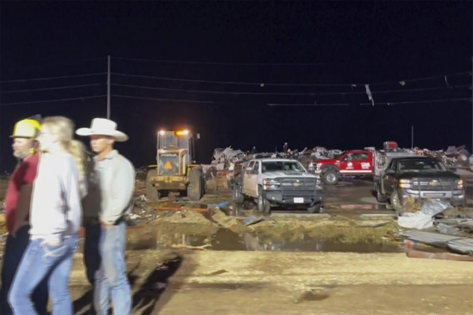 In this image made from video provided by KAMC/KLBK, people stand near debris in Matador, Texas, Wednesday, June 21, 2023, following storms went through the area. A line of severe storms produced multiple tornadoes Wednesday evening on the Rolling Plains in Texas, killing multiple people and causing significant damage around the northern town of Matador. (KAMC/KLBK via AP)