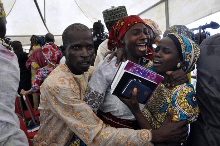 FILE - A girl that was kidnapped by Boko Haram extremists, celebrates with family members after her release with others, during a church service held in Abuja, Nigeria, on Oct. 16, 2016. On April 14, 2014, Boko Haram stormed the Government Girls Secondary School in the Chibok community in Borno state and forcefully took the girls as they prepared for science exams, sparking the #BringBackOurGirls social media campaign that involved celebrities worldwide including former U.S. First Lady Michelle Obama. (AP Photo/Olamikan Gbemiga, File)