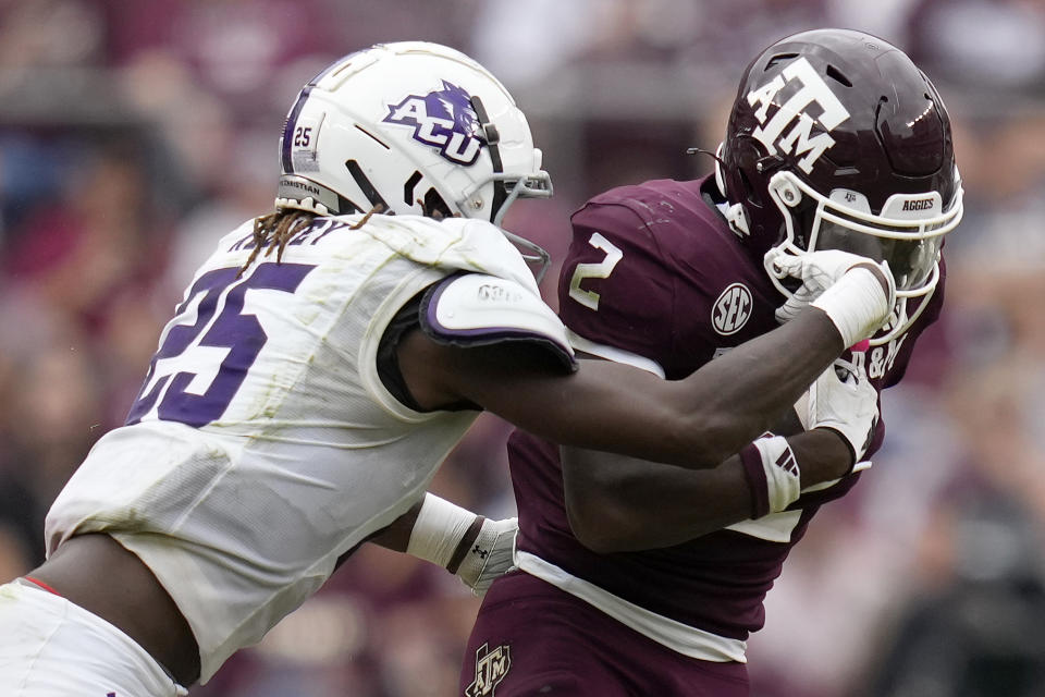 Abilene Christian linebacker Izaiah Kelley (25) grabs the face mask of Texas A&M running back Rueben Owens (2) while trying to tackle him during the third quarter of an NCAA college football game Saturday, Nov. 18, 2023, in College Station, Texas. (AP Photo/Sam Craft)